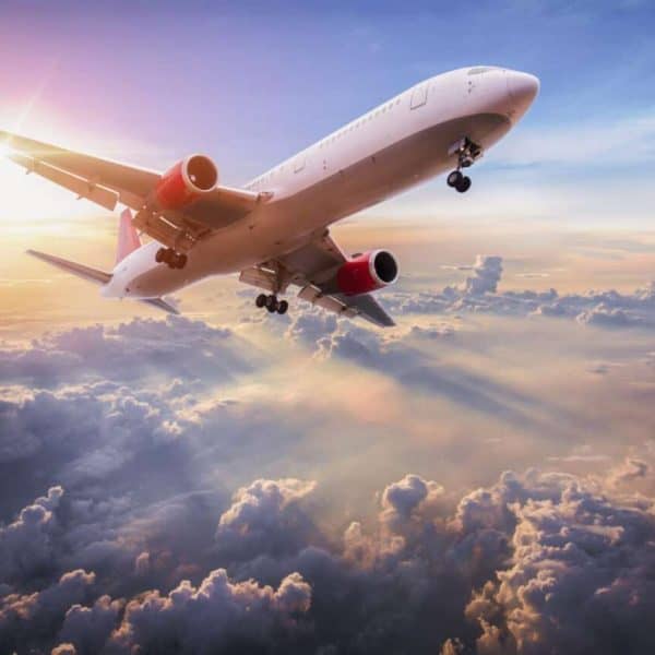 Landscape with aircraft is flying above clouds in the blue sky. Travel background with passenger plane. Commercial airplane. Private jet. Fast Travel and transportation concept